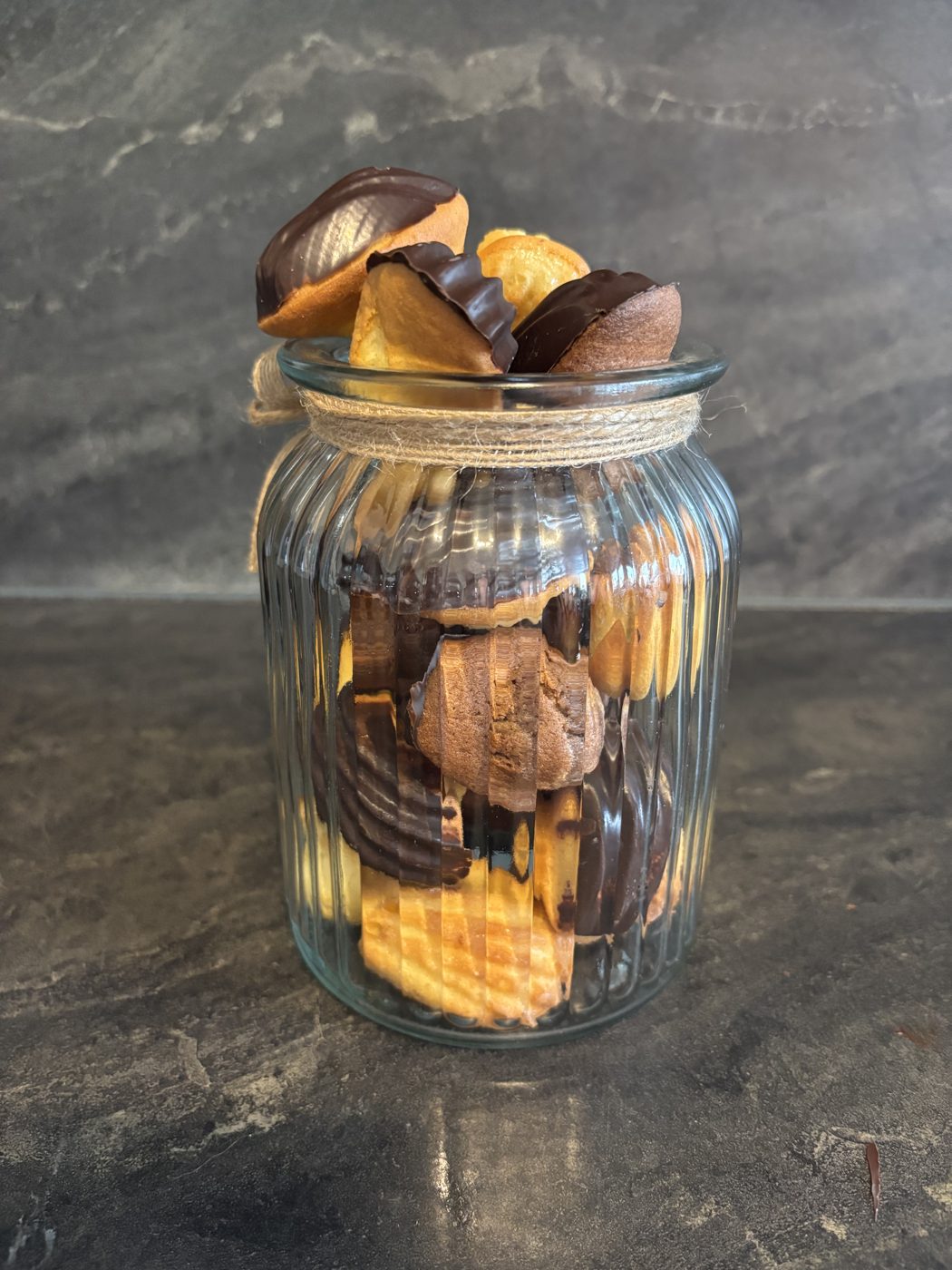 Bocal en verre garni de madeleines nature et nappées de chocolat